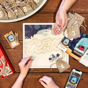 Family completing the Modern Christmas puzzle with pouches on the holiday table